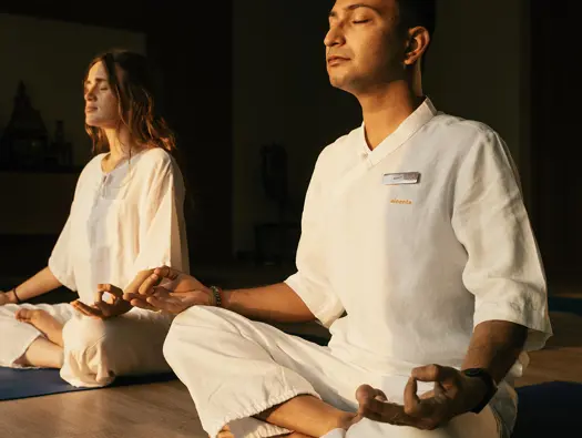 Two guests meditating together during The Companion Yoga Retreat at AYURAH